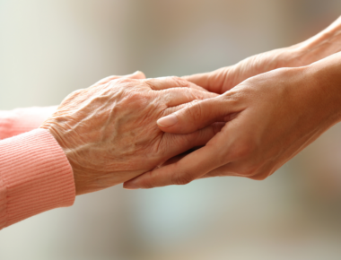 Old and Young People Holding Hands on Light Background, Closeup