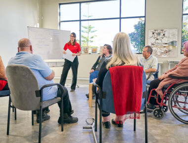 An MSWA counsellor speaks to a group of clients