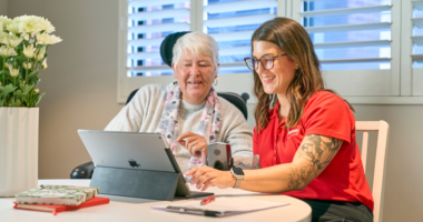 MSWA Client and staff next to a laptop.