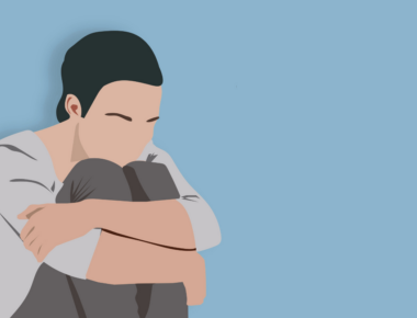 Individual hugging their knees.