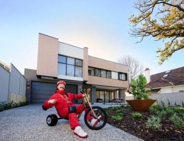 Man on trike poses outside the Mega Home.