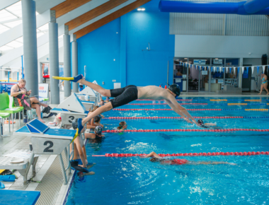 man diving into indoor pool