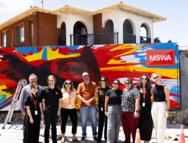 MSWA Marketing team and Client, Hank posing in front of his mural, I Found a Feather.