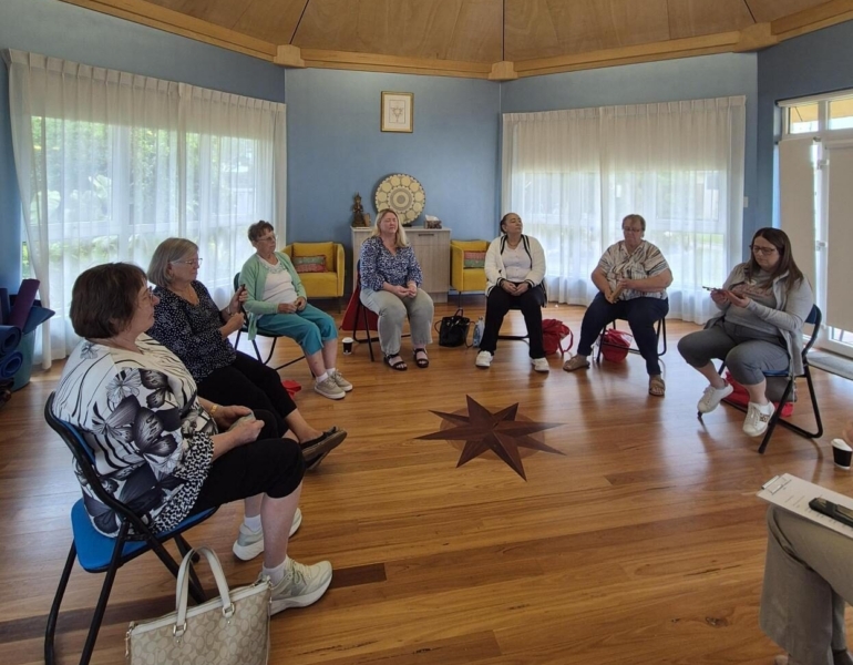 A group of people sit in a circle talking.