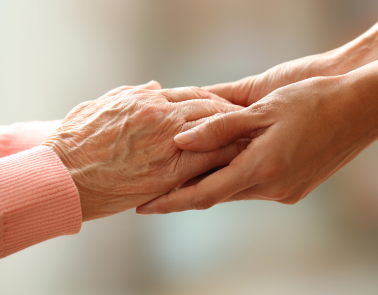 Old and Young People Holding Hands on Light Background, Closeup