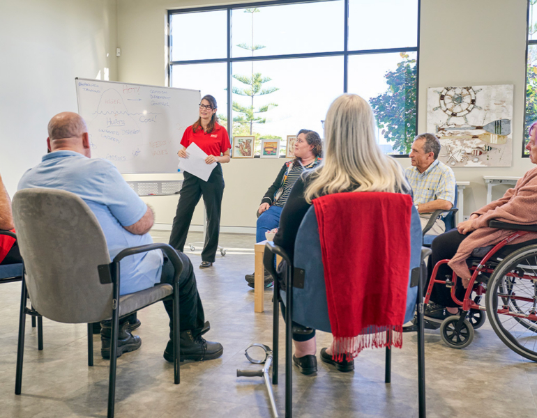 An MSWA counsellor speaks to a group of clients