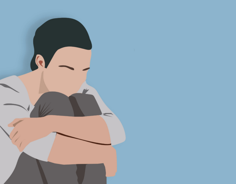 Individual hugging their knees.