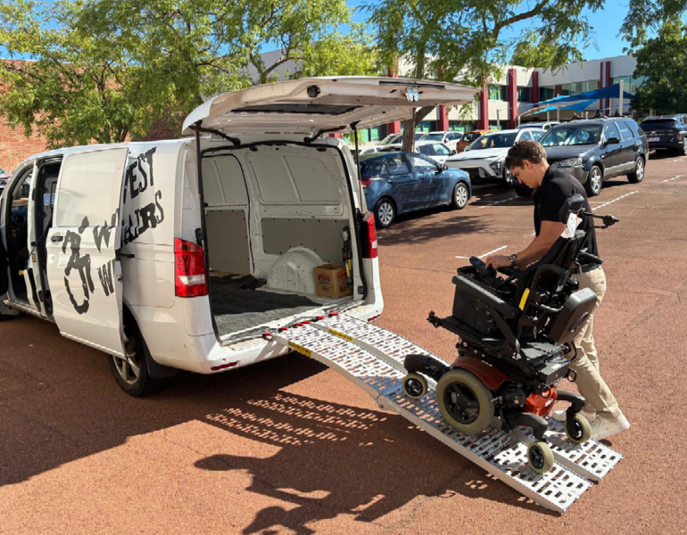 Man loading mobility scooter into the back of van via a ramp