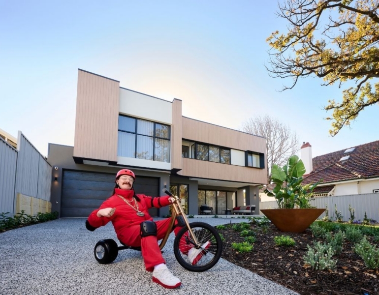 Man on trike poses outside the Mega Home.