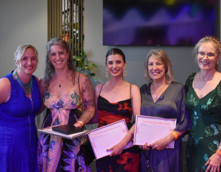 Four people holding certificates.