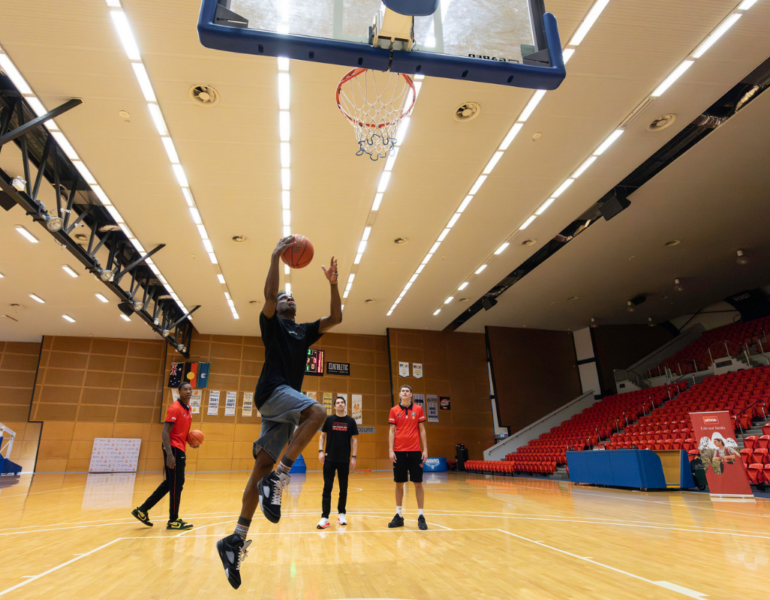 MSWA Client shooting a basketball shoot with the Perth Wildcats team.