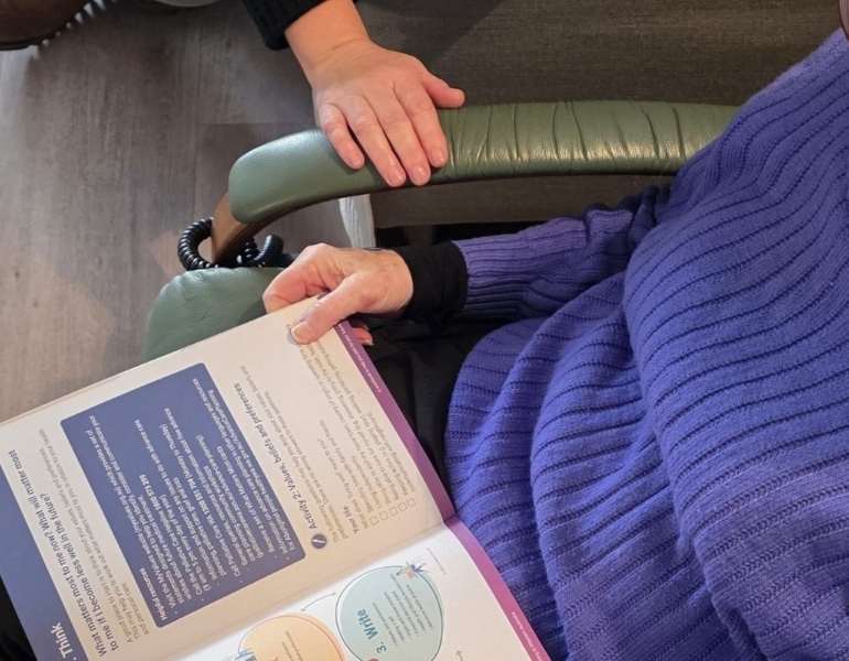 Book opened on a someone's lap.