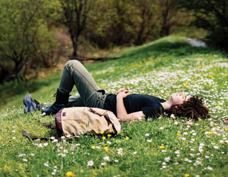 Stock image of man laying down on garden bed.