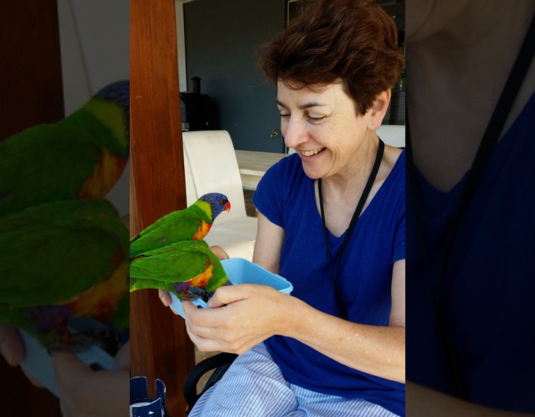 Woman feeding parrots