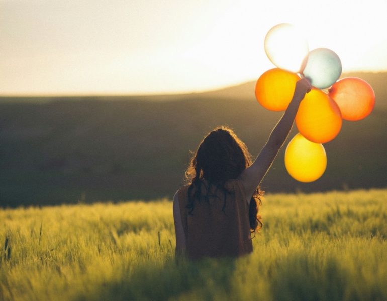 Woman holding balloons on a field