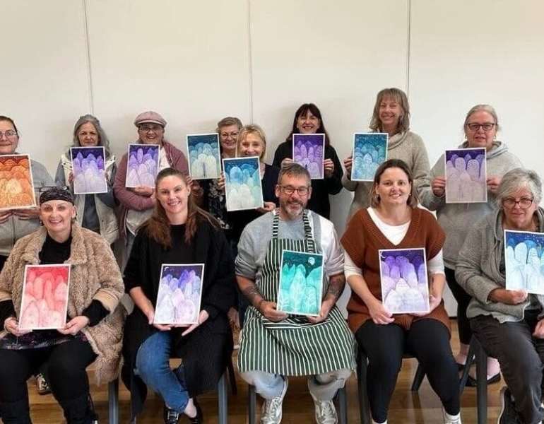 group of people posing with their paintings