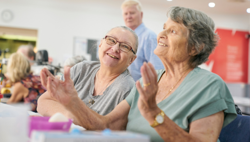 women smiling in a social, community setting