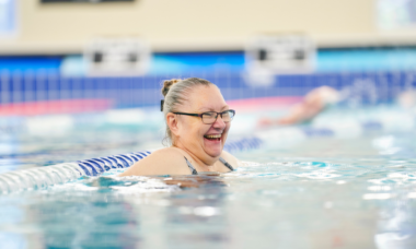 woman smiling and swimming in a pool