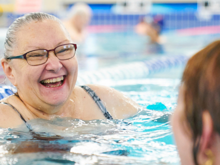 woman smiling and swimming in a pool
