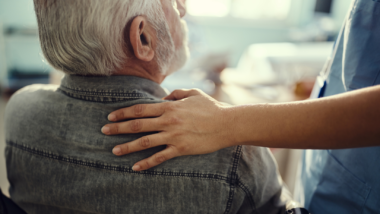 woman resting her hand on a man's shoulder in support