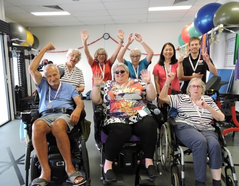 Group of people smiling and raising their arms in celebration