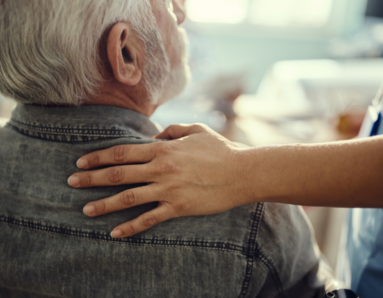 woman resting her hand on a man's shoulder in support