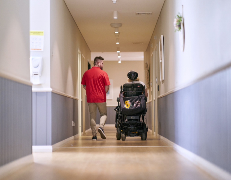 MSWA staff and client walking down a corridor at a service centre