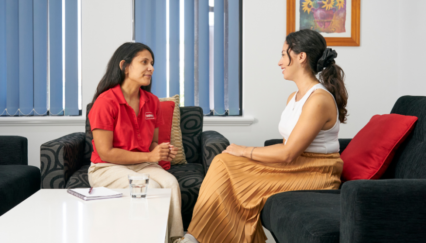 MSWA staff and client speaking while sitting on armchairs