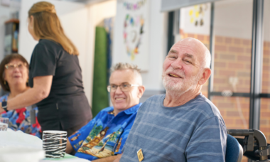 man smiling at the camera in a social, community setting