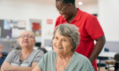 woman smiling at the camera in a social, community setting