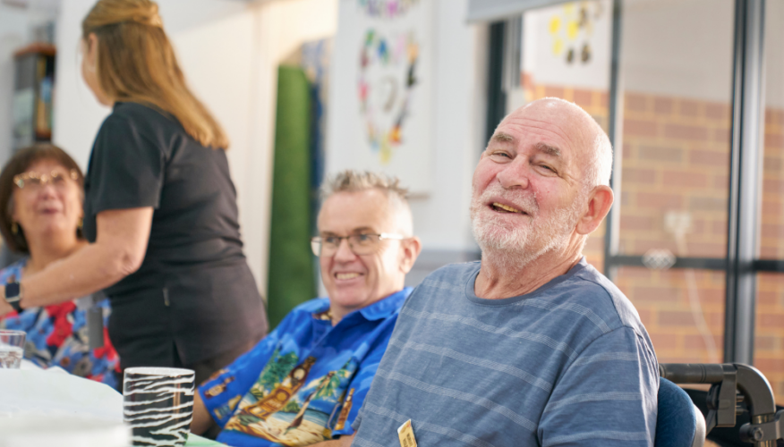 man smiling at the camera in a social, community setting