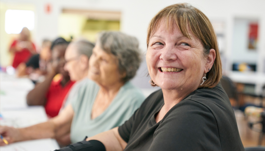 woman smiling at the camera in a social, community setting
