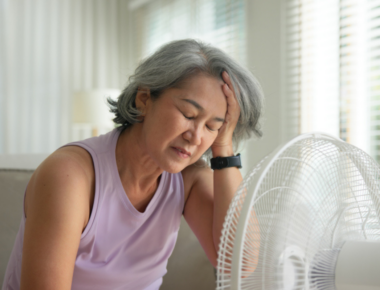 woman feeling hot in front of a fan