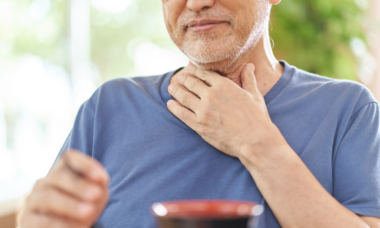 man with a hand on his throat