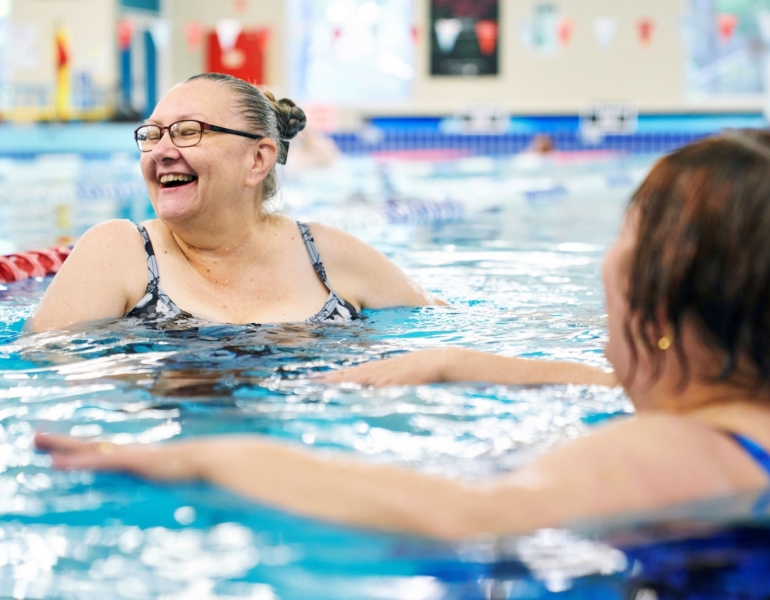 woman smiling and swimming in a pool