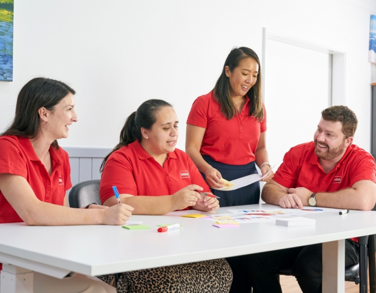 mswa staff around a table, pointing and reading something on the table