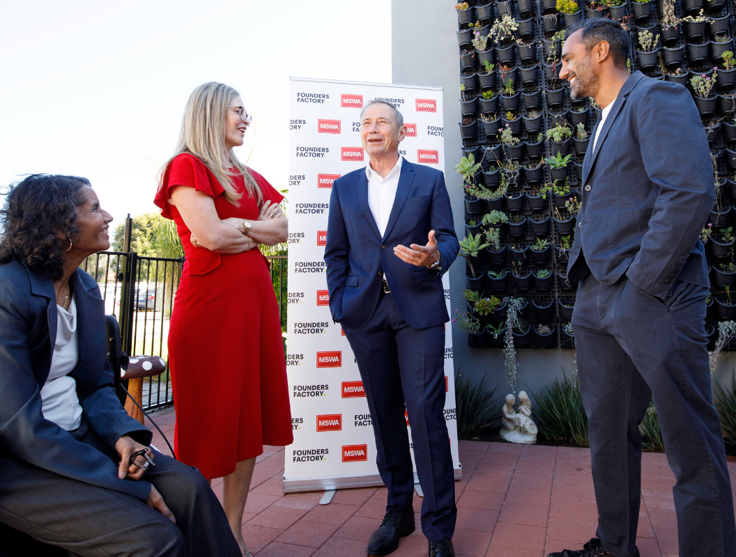 Premier, MSWA and Founders Factory chat to each other in front of media wall.