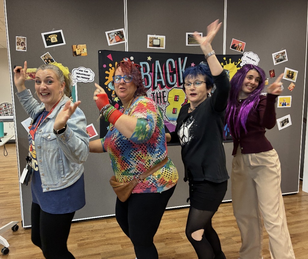 MSWA staff members dancing dress in 80s clothing.